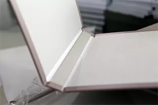 The inside pages are glued into the hard cover. Depending on the total page count, endsheets may also be used to secure the book block to the case.