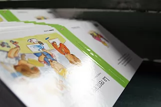 The cover artwork is printed onto a sheet and cut into shape. The front cover, back cover, and spine are printed onto one continuous sheet.