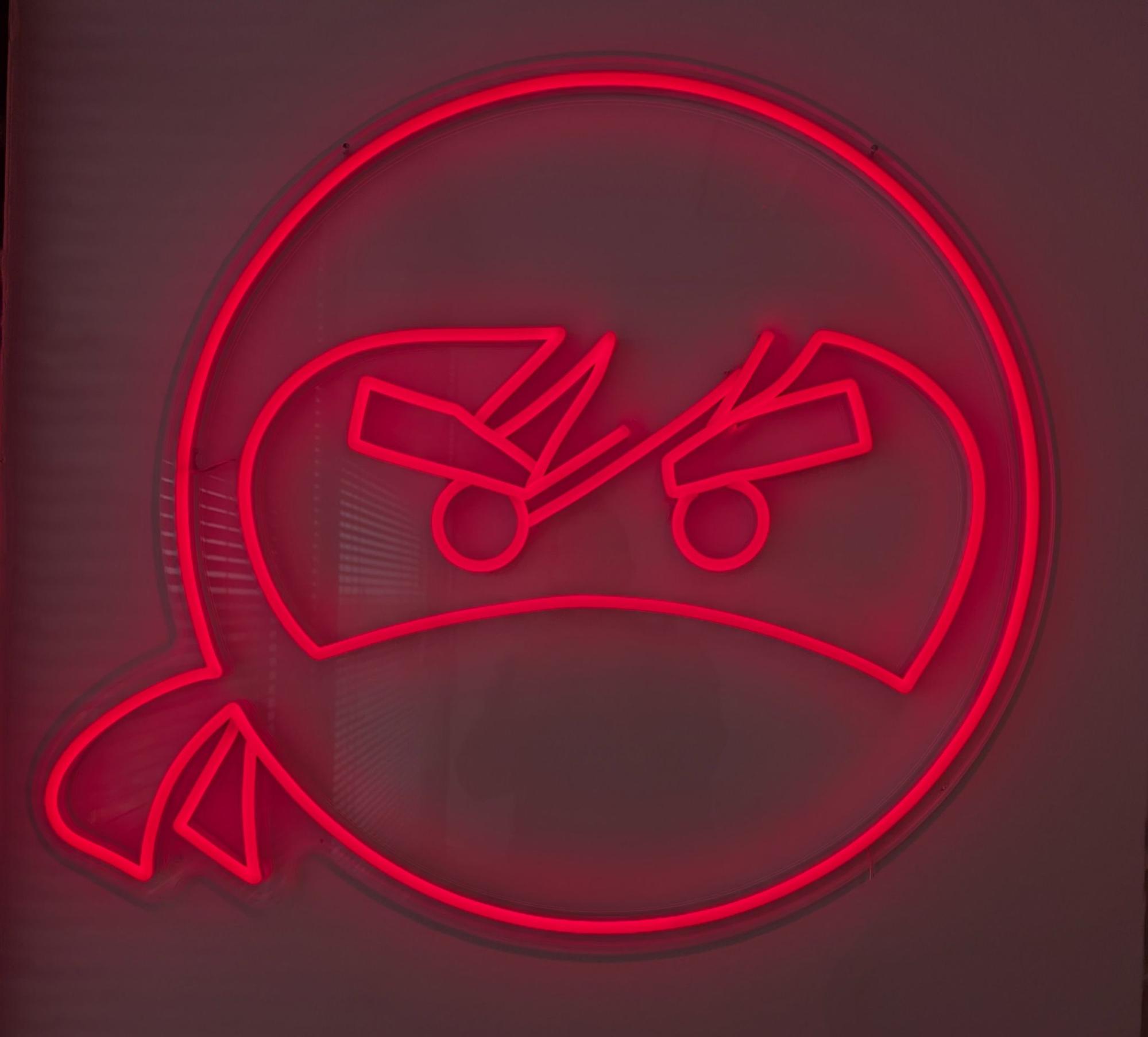 Inky, the PrintNinja ninja mascot, as a red neon sign